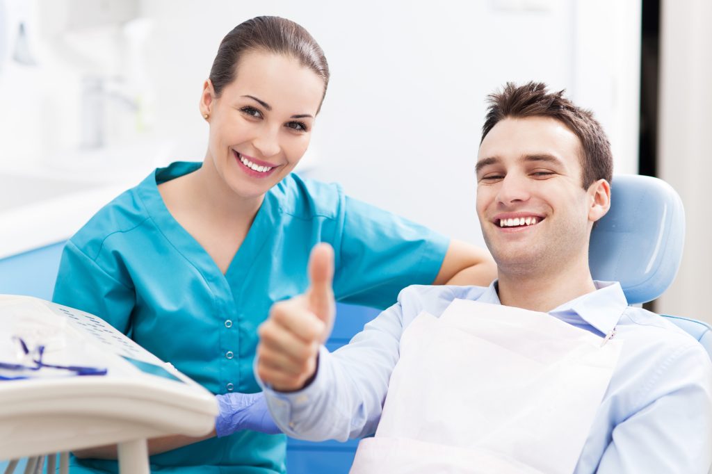 A man giving thumbs up at the dentist