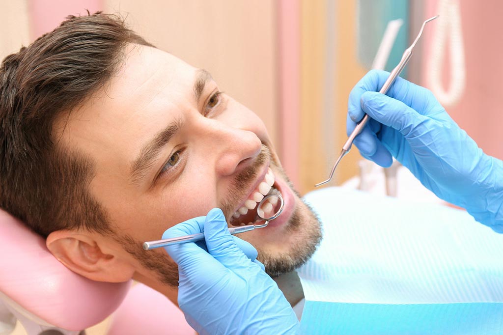 A male patient getting inspection at the dentist